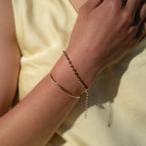The timeless appeal of our Dainty Bean Design Gold Bracelet makes it a true investment piece. Its classic and versatile design ensures that it will never go out of style, allowing you to enjoy its elegance for years to come. This bracelet is a beautiful addition to any jewelry collection and can be worn alone or layered with other bracelets for a personalized look.  18K gold plated on stainless steel. All the bracelets come in a beautiful jewelry pouch.