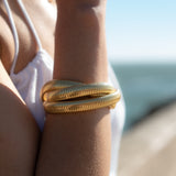 The Sia Triple Bracelet boasts an enchanting design that effortlessly blends classic and contemporary elements. Crafted from 18k gold plated on stainless steel, this bracelet emanates a radiant glow that illuminates your wrist, leaving a lasting impression.  18k gold plated on stainless steel. Three layer elastic bracelet.  All the bracelets come in a beautiful jewelry pouch.